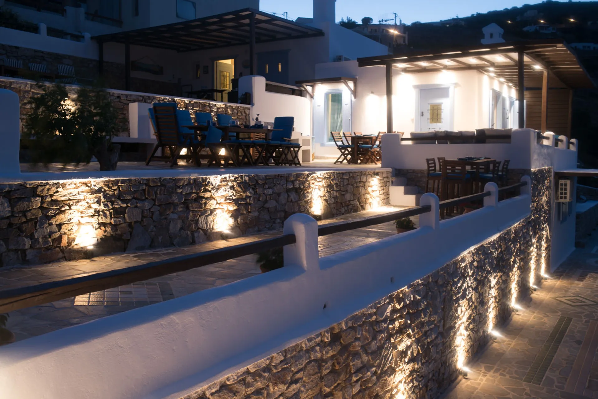 Exterior view of the stone-built Ermoupolis Panorama Art Villa in Syros, showcasing traditional architecture and luxury outdoor lighting.